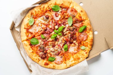 Beyaz arka planda karton kutuda pizza. Fesleğenli etli pizza. Lezzetli öğle veya akşam yemeği, fast food.