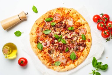 Beyaz arka planda pizza. Jambonlu, salamlı ve sosisli lezzetli et pizzası. Beyaz üzerine üst görünüm.