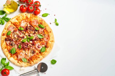 Beyaz arka planda pizza ve yemek malzemeleri. Jambonlu, salamlı ve sosisli lezzetli et pizzası. Üstteki görünüm beyaz ve metin için boşluk.