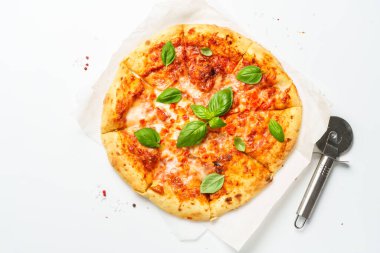 Beyaz arka planda fesleğen yapraklı pizza Margarita. Üst görünüm, kapat.