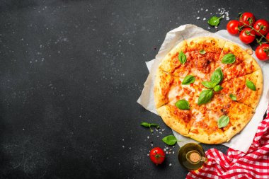 Siyah arka planda pizza margaritası ve yemek malzemeleri. Kopyalama alanı olan düz.
