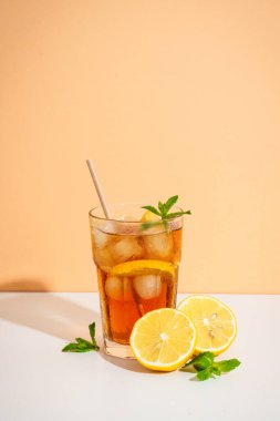 Limon ve buzlu buzlu çay. Renkli arka planda sert gölgeli yaz içeceği.