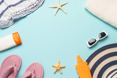 Mavi arka planda deniz kabukları olan plaj örtüsü ve aksesuarları. Tasarım için kopyalama alanı olan üst görünüm.