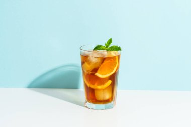 Limon ve buzlu buzlu çay. Renkli arka planda sert gölgeli yaz içeceği.