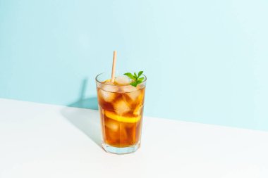 Renkli arka planda buzlu çay. Sert gölgeli soğuk yaz içeceği.