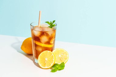 Limon ve buzlu buzlu çay. Renkli arka planda sert gölgeli yaz içeceği.