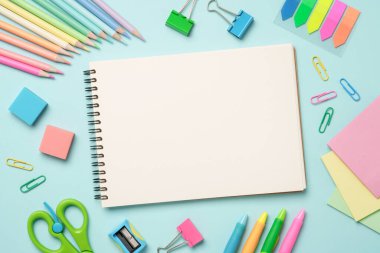 Okul ve sanat için kalem, kalem ve diğer malzemelerle mavi arkaplan üzerine albüm veya eskiz kitabı.