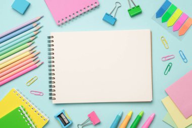 Okul ve sanat için kalem, kalem ve diğer malzemelerle mavi arkaplan üzerine albüm veya eskiz kitabı.