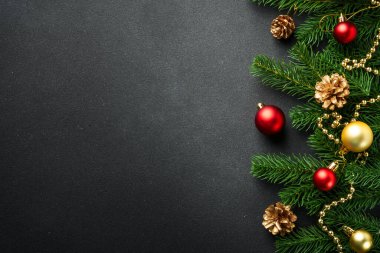 Noel arkaplanı köknar ağacı ve siyah üzerine renkli tatil süslemeleri ile yatıyordu..