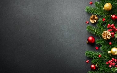 Noel arkaplanı köknar ağacı ve siyah üzerine renkli tatil süslemeleri ile yatıyordu..