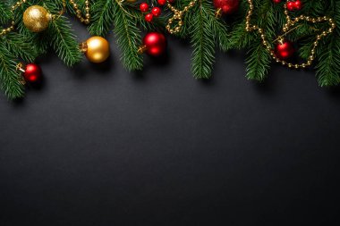 Siyah Noel arkaplanı dümdüz uzanıyordu. Siyah arka planda tatil süslemeleri olan Noel ağacı.