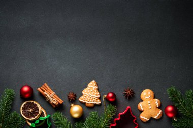 Noel yemeği ve siyahta pişirmek için malzemeler. Zencefilli kurabiye, baharat ve Noel süslemeleri. Metin için boşluk ile düz uzandı.