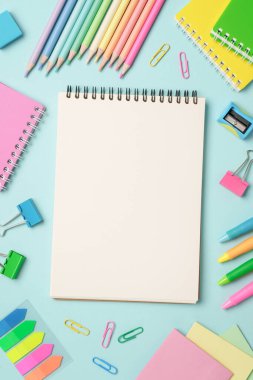 Not defteri, kalemler, kalemler ve diğer malzemeler. Düz resim mavi arkaplanda yatıyordu.