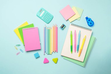 Mavi arka planda okul malzemeleri. Okul ve sanat için not defterleri, kalemler, kalemler ve diğerleri. Düz görünüm.