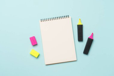 Mavi arka planda çizim defteri ve işaretler. Metin için alanı olan düz resim.