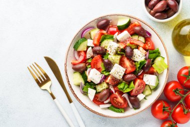 Beyaz masada zeytinli Yunan salatası. Taze sebze, peynir ve zeytinyağı. Düz yatıyordu