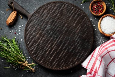 Baharat ve bitkiler, siyah arka planda kesim tahtası. Metin için boşluk ile düz uzandı.