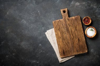 Siyah arka planda baharatlarla kesme tahtası. Kopyalama alanı olan üst görünüm.