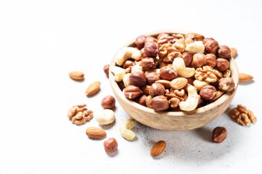 Beyaz arka planda fındık çeşitleri. Badem, fındık, ahşap kasede kaju..