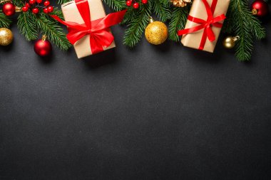 Siyahta Noel tebrik kartı. Noel ağacı ve hediye kutusu ve tatil süslemeleri düzdü..