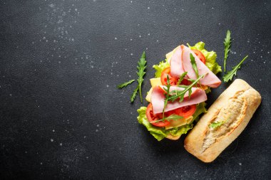 Marul, peynir, domates ve jambonlu Ciabatta sandviçi. Fast food, aperatif veya öğle yemeği. Kopyalama alanı olan üst görünüm.
