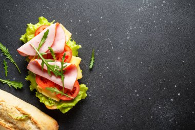 Marul, peynir, domates ve jambonlu Ciabatta sandviçi. Fast food, aperatif veya öğle yemeği. Kopyalama alanı olan üst görünüm.