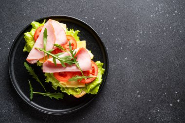 Marul, peynir, domates ve jambonlu Ciabatta sandviçi. Kopyalama alanı olan düz.