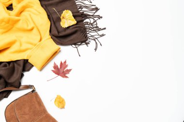 Sonbahar kumaşı ve aksesuarları beyaz arka planda fotokopi alanı ile. Düz yatıyordu. Atkı, yapraklı süveter çantası..
