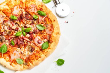 Beyaz arka planda pizza ve yemek malzemeleri. Jambonlu, salamlı ve sosisli lezzetli et pizzası. Üstteki görünüm beyaz ve metin için boşluk.