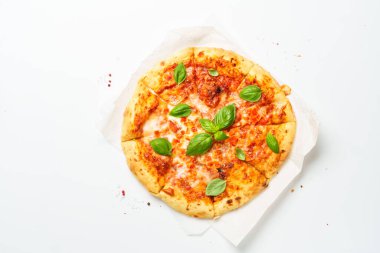 Beyaz arka planda fesleğen yapraklı pizza Margarita. Üst görünüm, kapat.