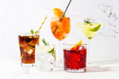 Beyaz arka planda alkollü kokteyl içecekler. Aperol spritz, negroni, Margarita, Küba libre ve jin tonik. Güneşli beyaz arkaplan.
