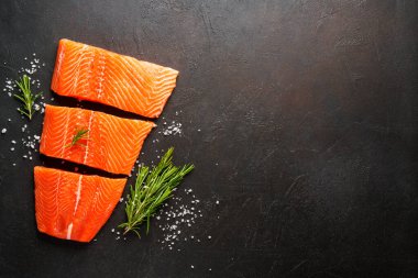 Baharatlı çiğ somon filetosu. Siyah arkaplanda kopyalama alanı olan üst görünüm.