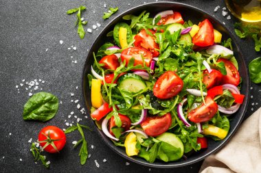 Sağlıklı yemek, diyet yemek. Sebzeli taze salata. Siyah arkaplanda üst görünüm.