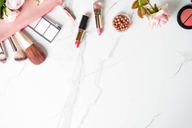 Beyaz arka planda gül çiçekli makyaj ürünleri olan kozmetik çanta. Kopyalama alanı olan düz.