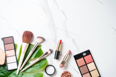 Beyaz arka planda kozmetik ürünleri. Palet, fırça ve ruj. Kopyalama alanı olan üst görünüm.