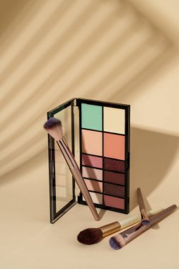 Göz falı paleti ve koyu gölgeli renkli arka planda fırçalar.