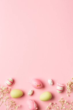 Paskalya arkaplanı pembeye uzanıyordu. Kopya alanı olan renkli yumurta ve çiçekler.