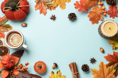 Şükran Günü geçmişi. Örgü süveter, dökülen yapraklar ve mavi arka planda el yapımı mum..