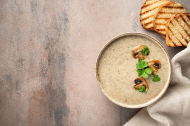 Mutfak masasında el işi kasesinde mantar çorbası püresi. Sağlıklı yiyecekler. Üst görünüm.