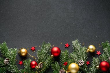 Noel arka planında köknar ağacı ve siyahların üzerinde tatil süslemeleri vardı. Tasarım için alanı kopyala.