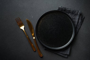 Siyah çatal bıçak takımlı siyah tabak. Kopyalama alanı olan düz.