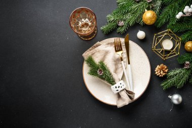 Noel sofrası. Noel yemeği - siyah arka planda siyah tabaklar ve çatal bıçak takımları.