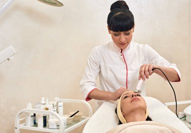 Young woman having procedure of skin rejuvenation in beauty salon