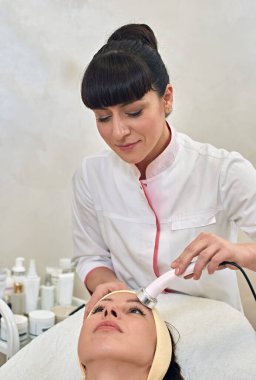 Young woman having procedure of skin rejuvenation in beauty salon