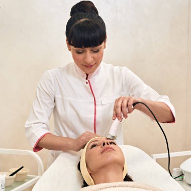 Young woman having procedure of skin rejuvenation in beauty salon
