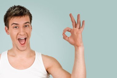 Genç adam mavi arkaplanda işaret ve sembol gösterir