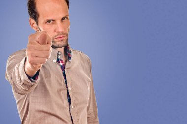 Genç adam mavi arkaplanda incir işareti gösteriyor