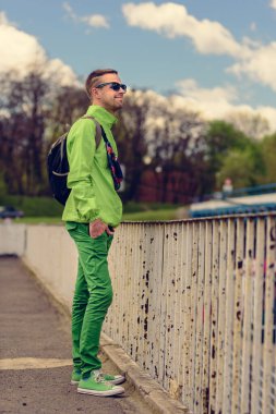 Sırt çantasıyla gezen yakışıklı bir gencin portresi.