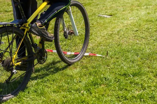 Erkek bisikletçinin yeşil çimlerin üzerine su koyduğu yakın plan.