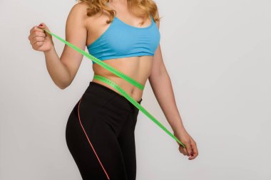 Genç, güzel bir kız, zayıf vücudunu ölçüyor.